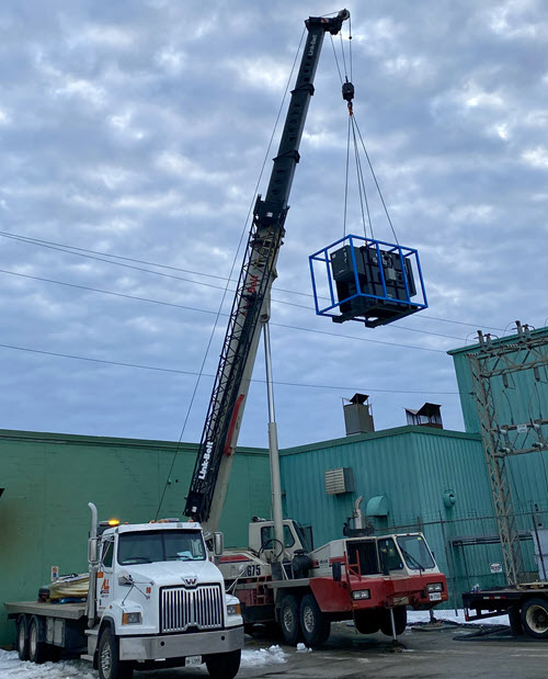A crane lifting a large transformer.