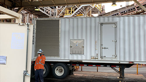 Technician standing by a generator